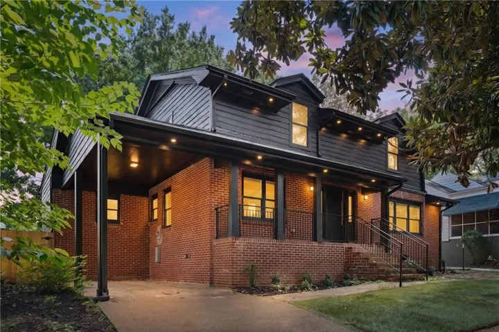 Brick and siding exterior with dormer windows, covered front entrance, and a covered carport with recessed lighting