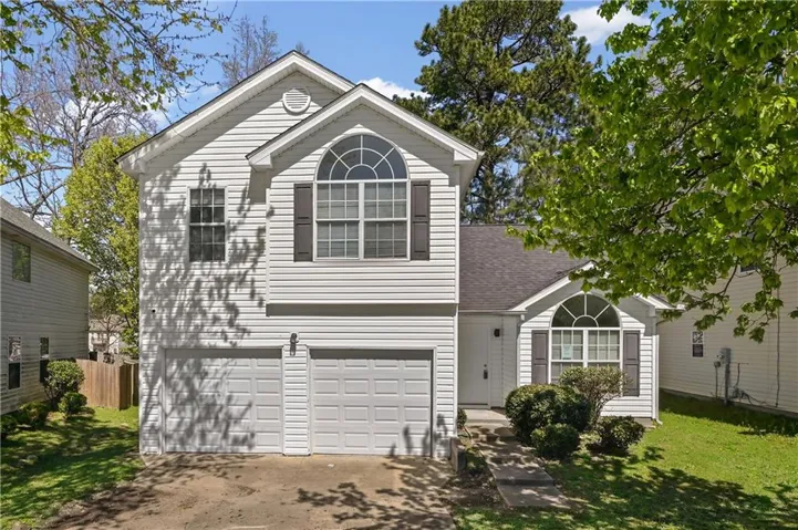 Two-story residence featuring white siding and a two-car garage