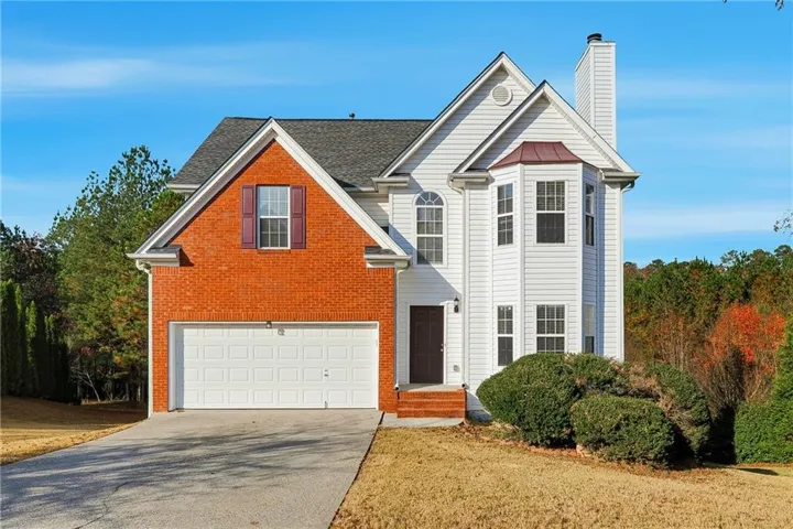 Traditional-style home featuring brick front, concrete driveway, and an attached two-car garage.