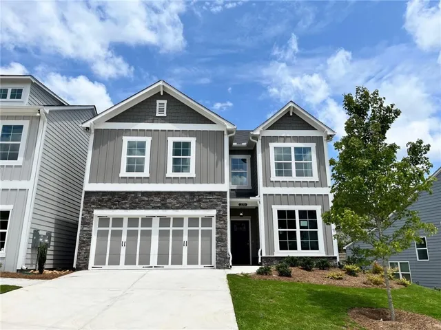 Contemporary two-story residence featuring a gray and white exterior with stone accents