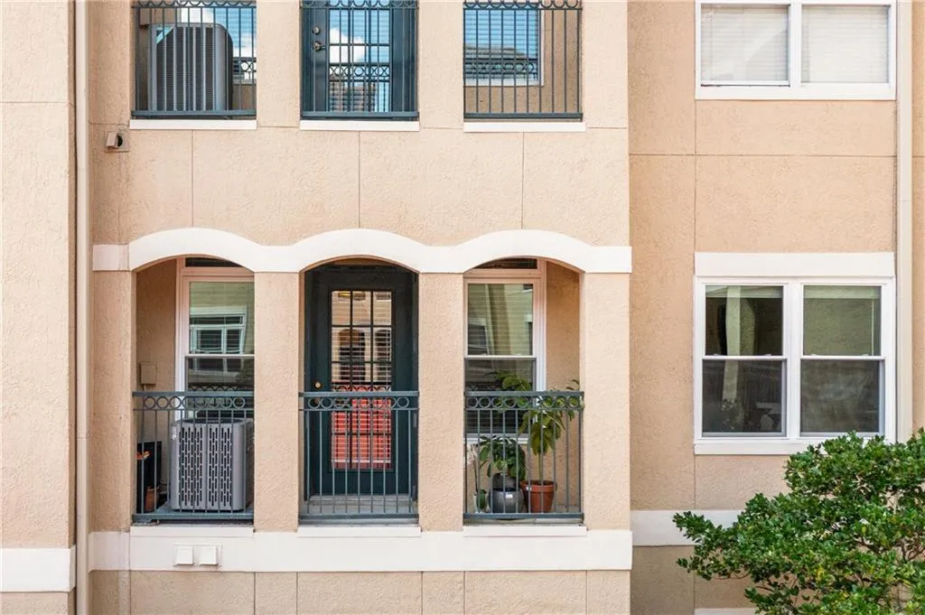 View of exterior entry featuring stucco siding and a balcony