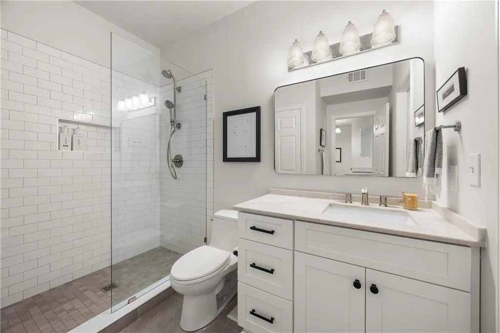 Bathroom featuring vanity, a tile shower, and tile patterned floors