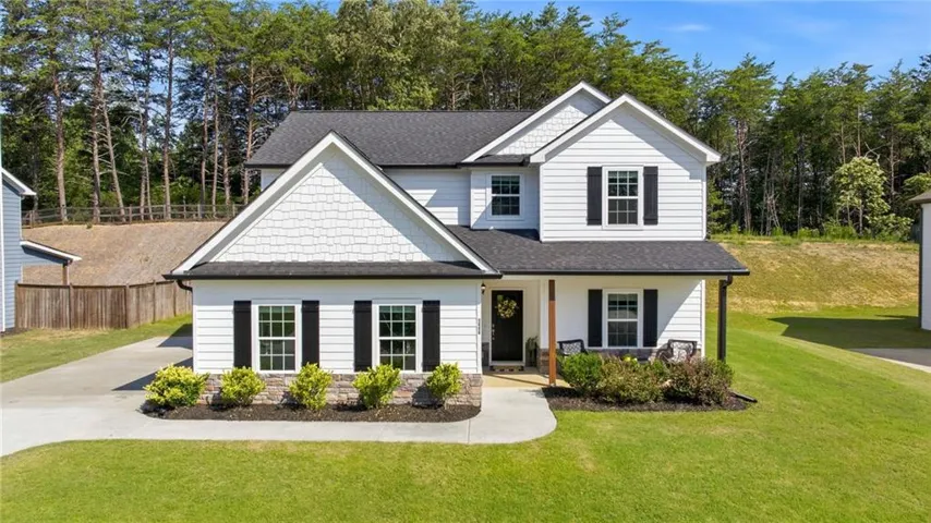 Two-story residence featuring white siding and dark shutters