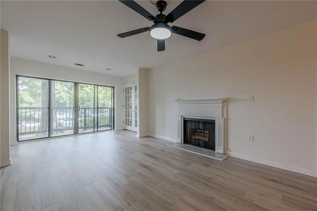 Unfurnished living room with light wood-type flooring, a fireplace, and ceiling fan