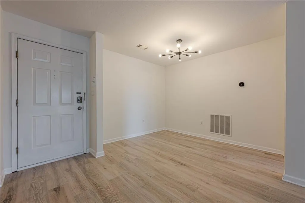 Unfurnished dining area featuring a chandelier and light wood-style flooring