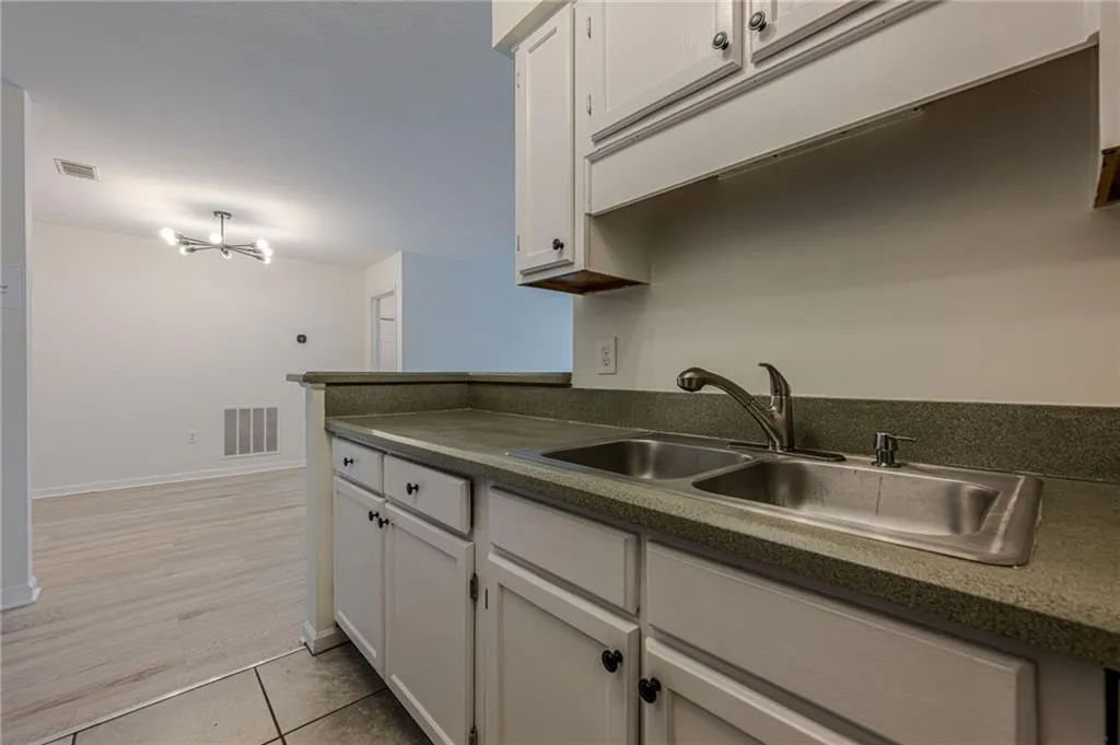 Kitchen with white cabinets, dark countertops, and light tile patterned floors