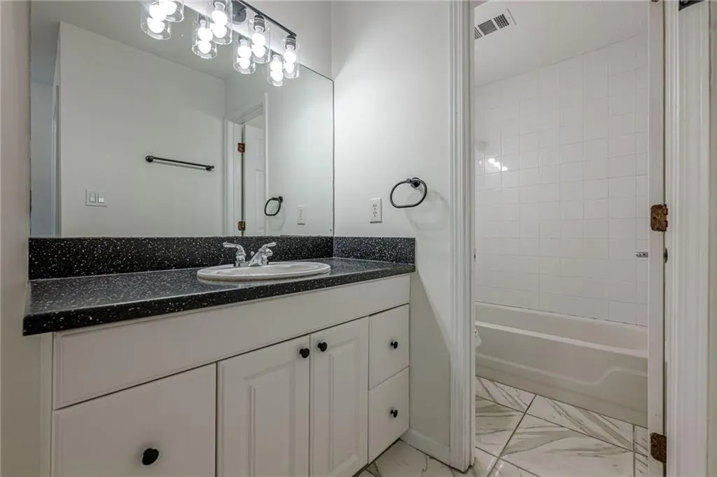 Bathroom featuring vanity and shower / washtub combination