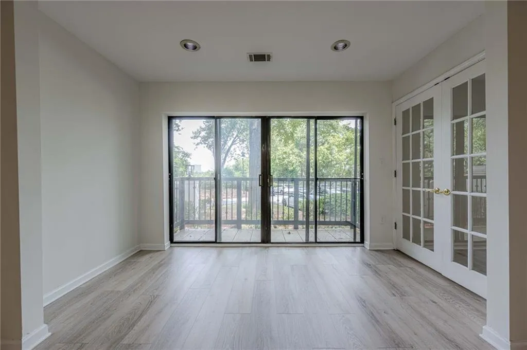 Empty room with light wood-type flooring, french doors, and recessed lighting