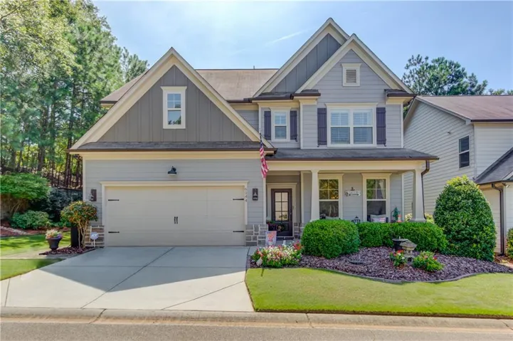 Two-story facade with gabled roof lines, attached two-car garage, covered entry porch, and decorative shutters