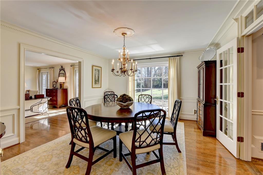 Dining space featuring an inviting chandelier, ornamental molding, and light wood-type flooring