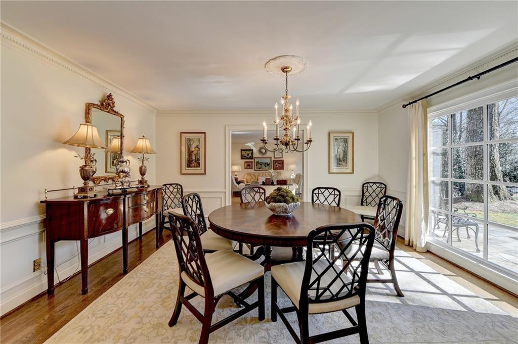 Dining space featuring light hardwood / wood-style flooring, crown molding, and a notable chandelier