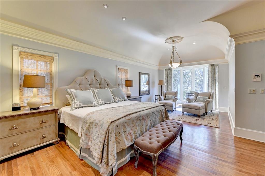 Bedroom with crown molding, vaulted ceiling, and light wood-type flooring