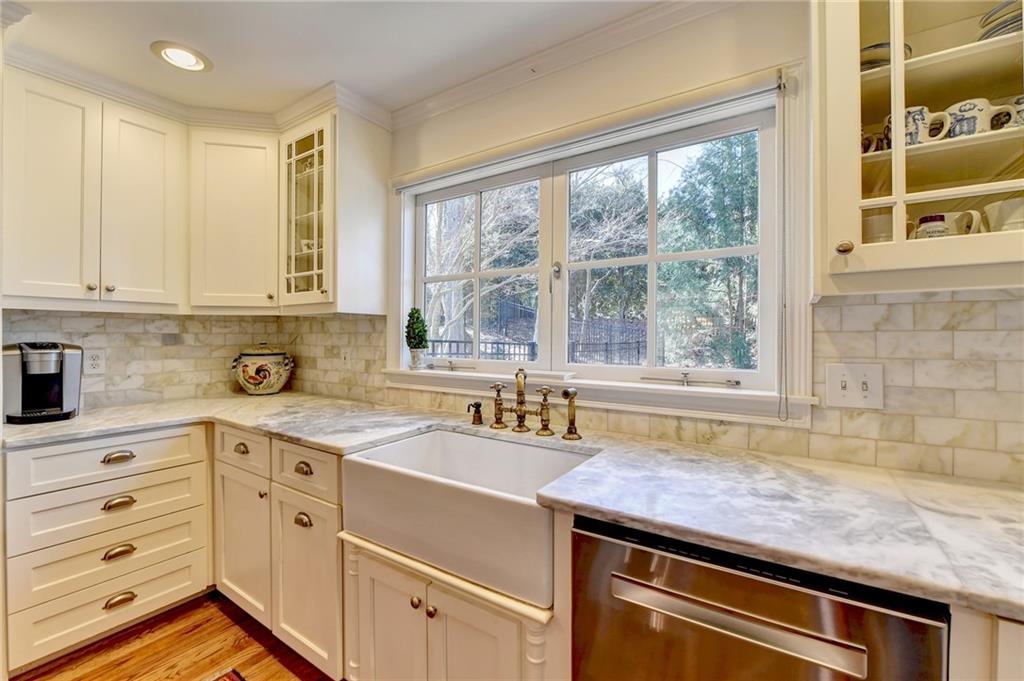 Kitchen featuring tasteful backsplash, dishwasher, and light wood-type flooring