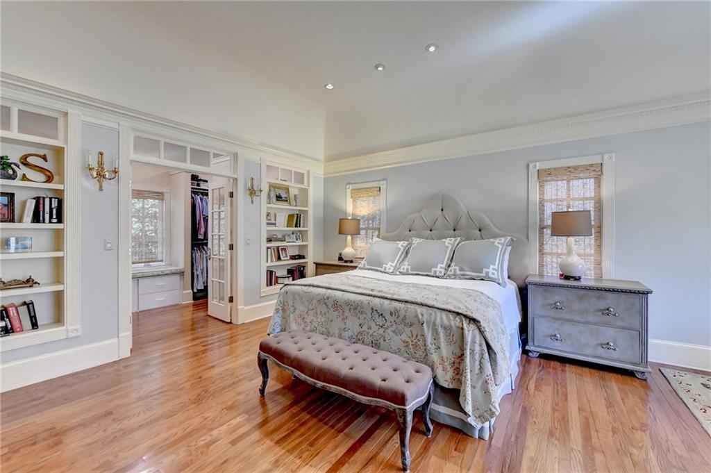 Bedroom with light hardwood / wood-style flooring and a walk in closet