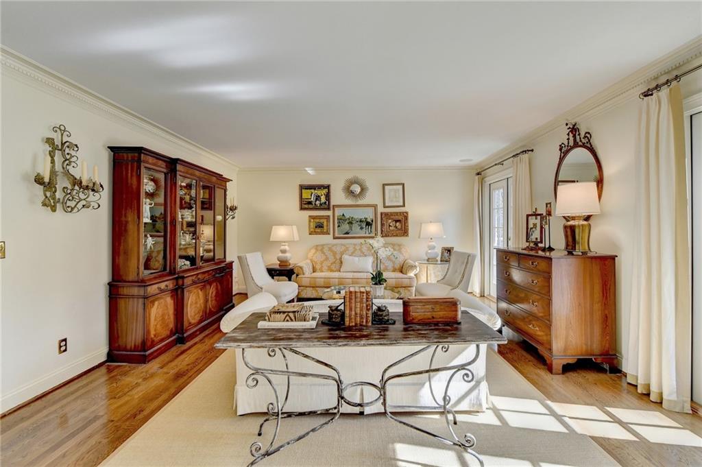 Living room with light hardwood / wood-style flooring and ornamental molding