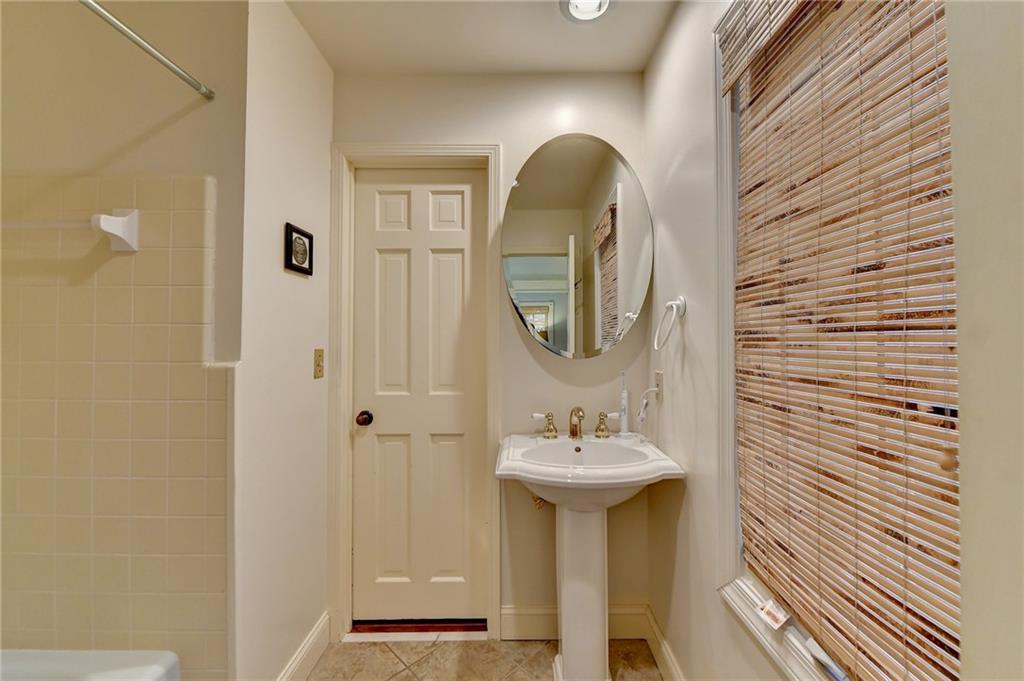 Bathroom with bathtub / shower combination and tile flooring