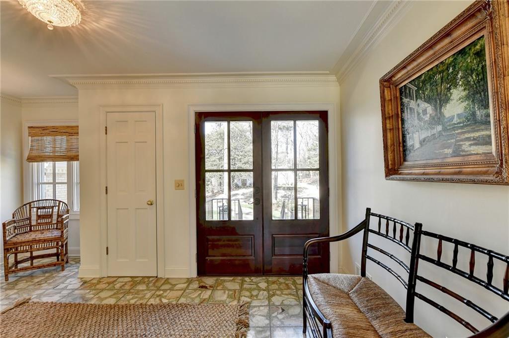 Tiled entrance foyer featuring crown molding, a healthy amount of sunlight, and french doors