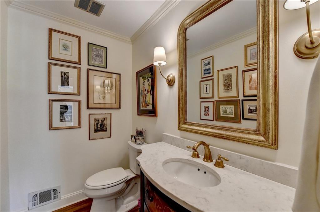 Bathroom with toilet, ornamental molding, and oversized vanity