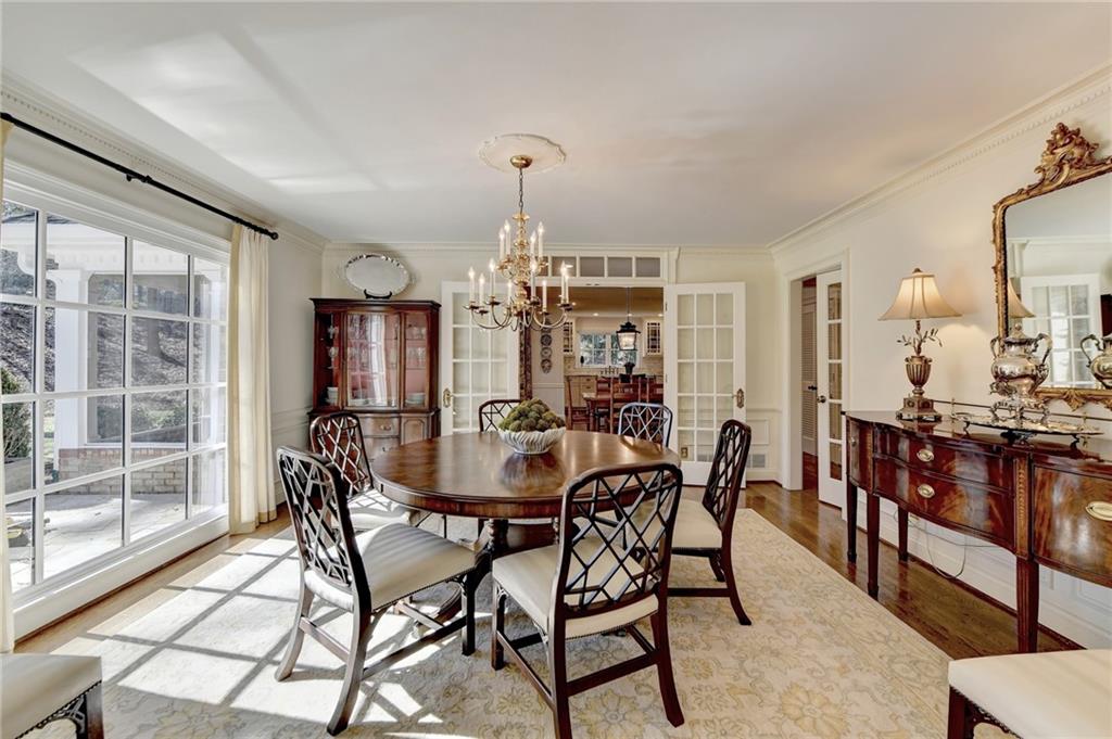 Dining space featuring light wood-type flooring, an inviting chandelier, and crown molding
