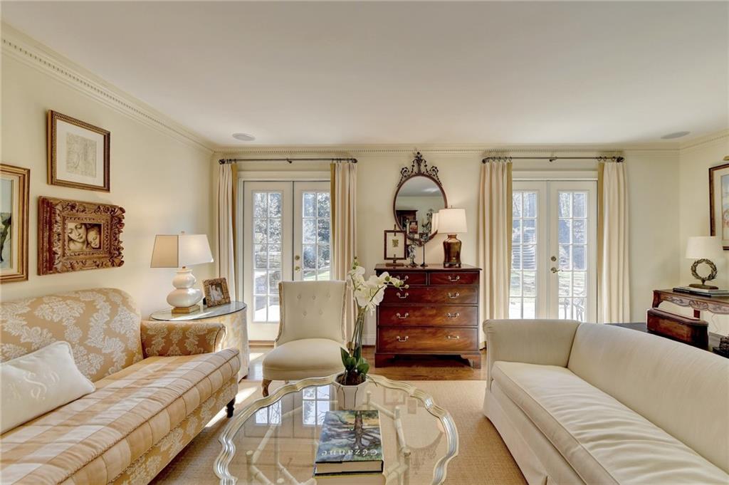 Living room with plenty of natural light, crown molding, and french doors