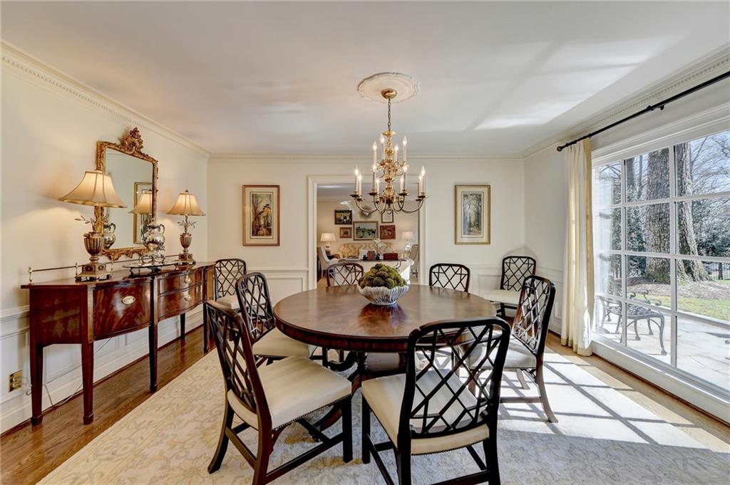 Dining area featuring a chandelier, light hardwood / wood-style floors, a healthy amount of sunlight, and ornamental molding