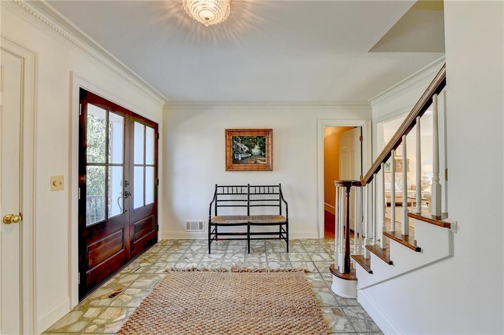 Tiled entrance foyer with ornamental molding and french doors