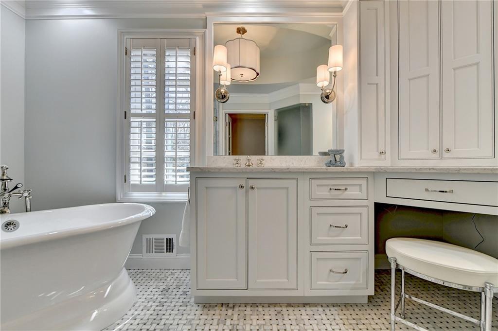 Bathroom featuring plenty of natural light, tile floors, crown molding, and vanity with extensive cabinet space