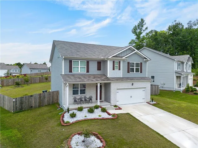 Two-story residential property featuring a light blue siding exterior with white brick accents