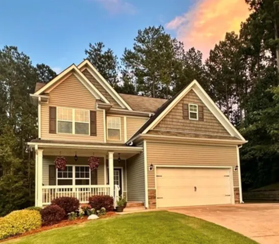 Two-story residence featuring a covered front porch, a two-car garage, and a gabled roofline