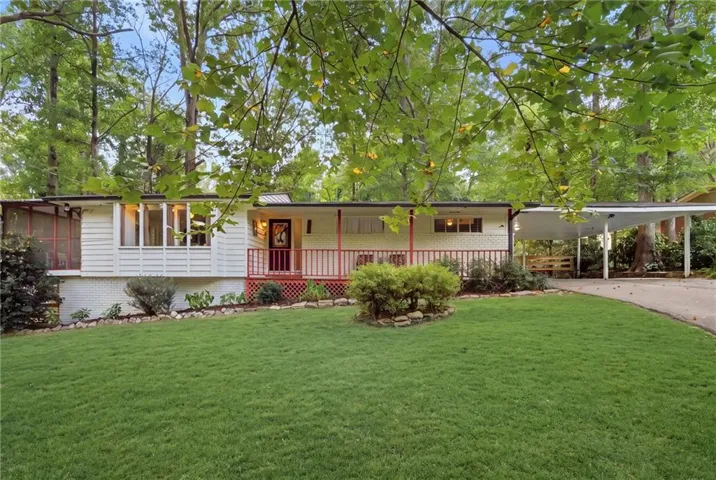 White siding exterior, red porch railings, prominent front windows, attached carport, and a screened porch