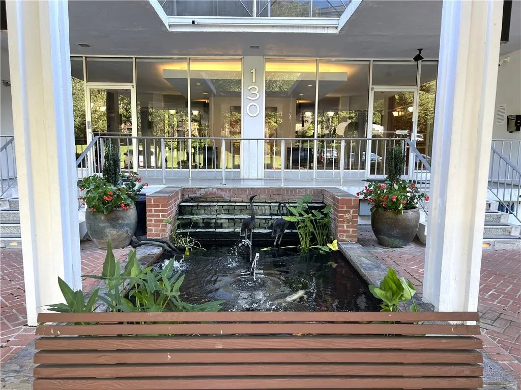 Beautiful entrance to building complete with koi pond in front