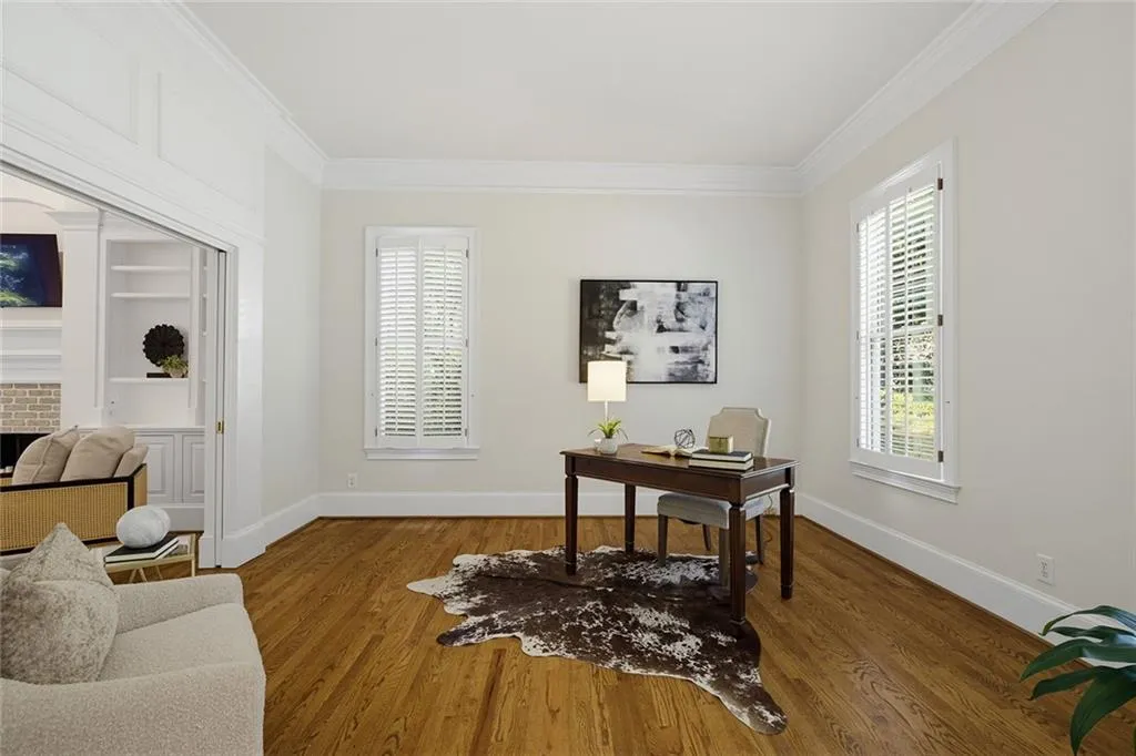 Hardwood flooring, crown molding, plantation shutters, and recessed built-in shelving