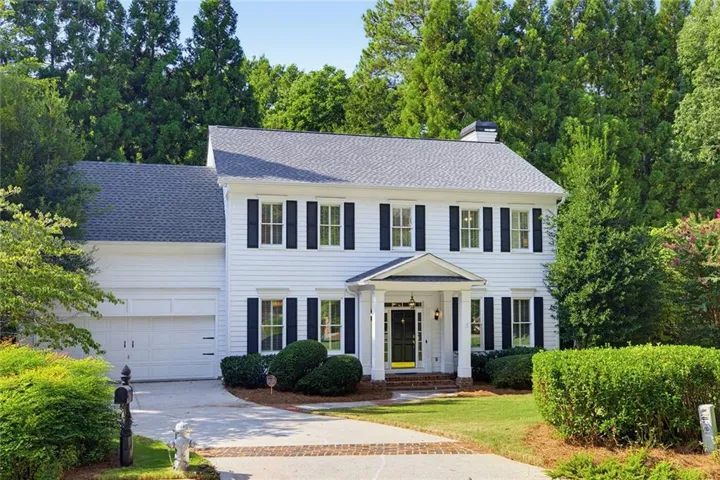 White siding exterior with a dark shingle roof and black shutters