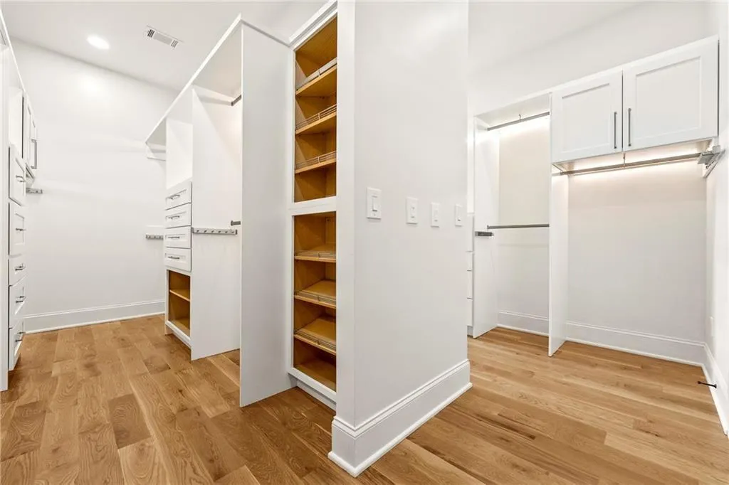 Spacious Primary closet with light wood finished floors Spacious Primary closet with light wood finished floors