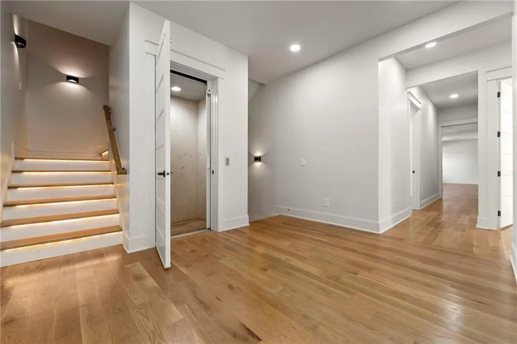 Second level hallway with light wood finished floors, stairs, and recessed lighting Second level hallway with light wood finished floors, stairs, and recessed lighting