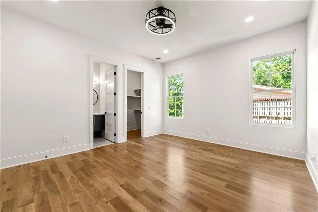 View of bedroom with light wood finished floors, a custom closet, recessed lighting, and ensuite bathroom View of bedroom with light wood finished floors, a custom closet, recessed lighting, and ensuite bathroom