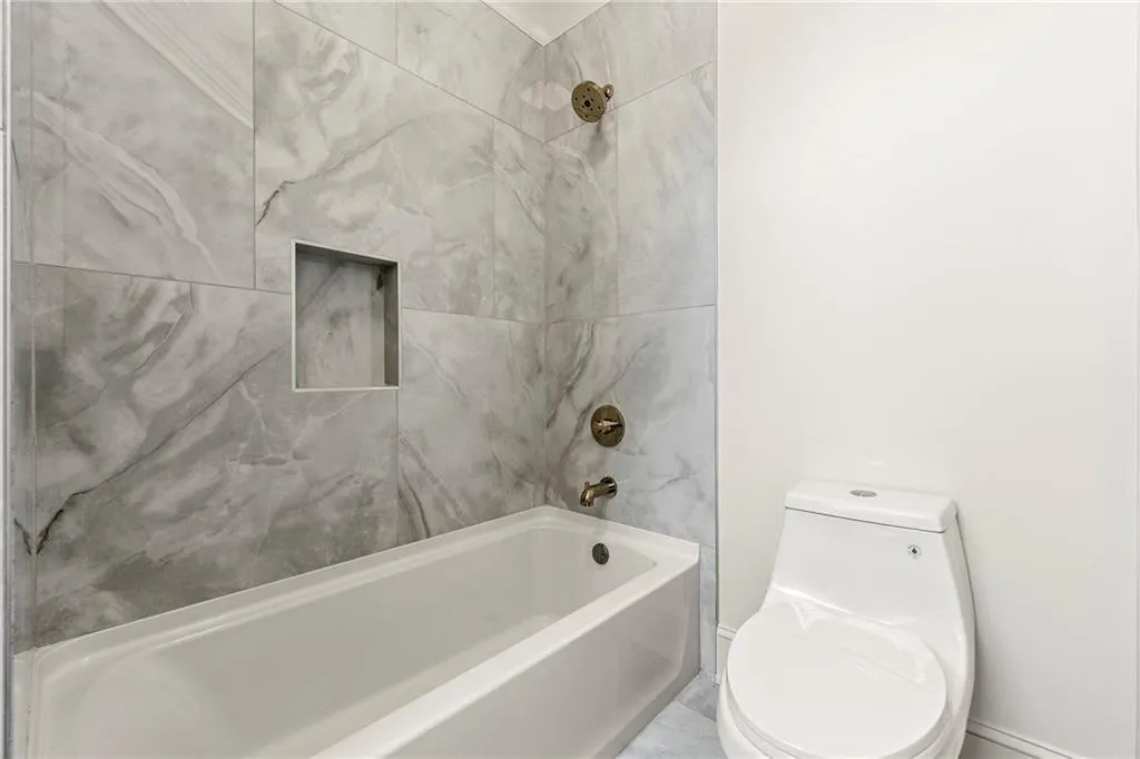 Bathroom featuring toilet and bathtub / shower combination Bathroom featuring toilet and bathtub / shower combination