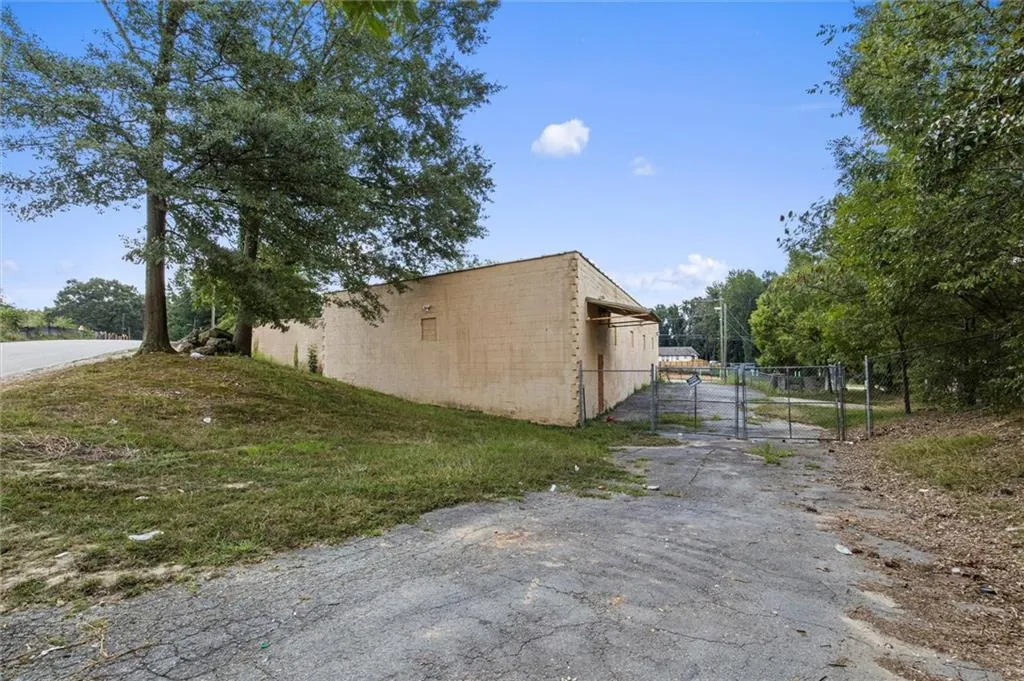 View of side of property featuring a gate and concrete block siding