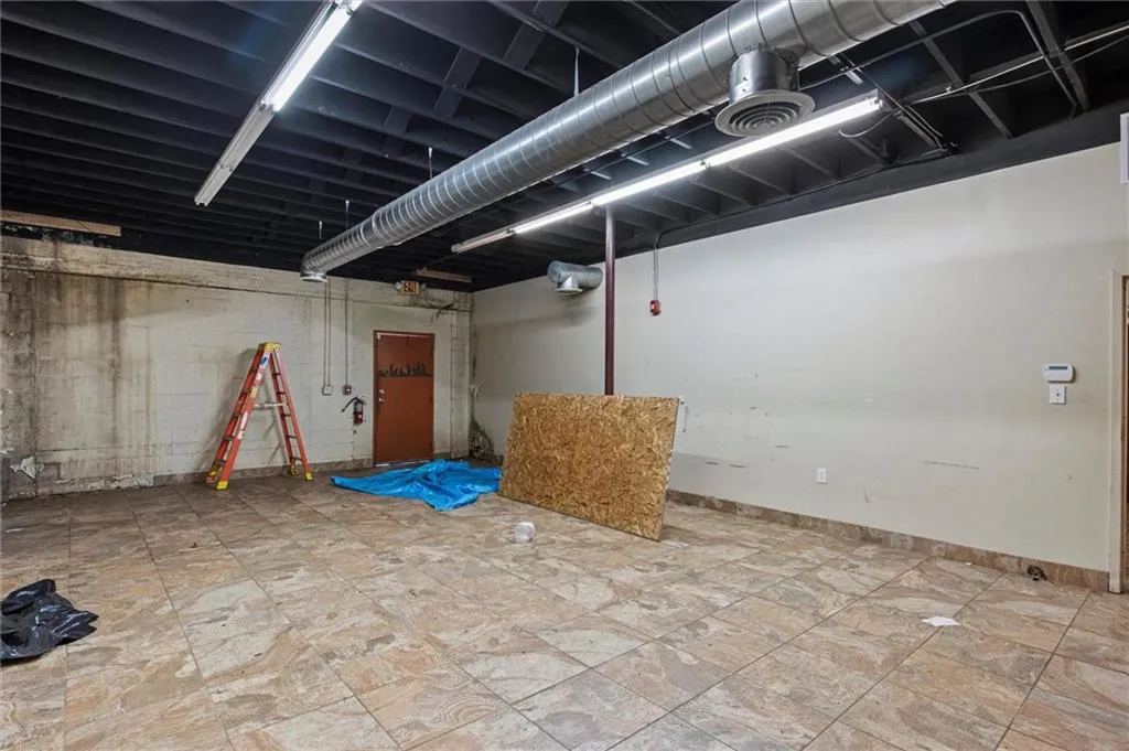 Basement featuring baseboards and concrete block wall