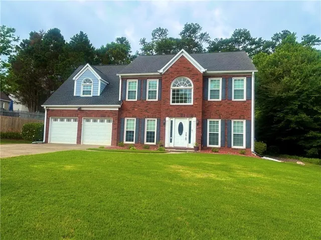 Red brick exterior featuring white trim and blue window shutters