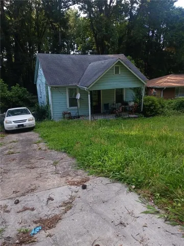 Bungalow with roof with shingles and asphalt driveway