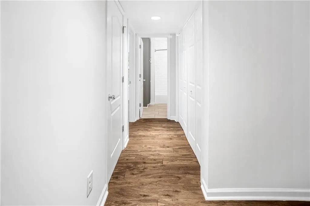 Corridor featuring dark wood-type flooring and recessed lighting