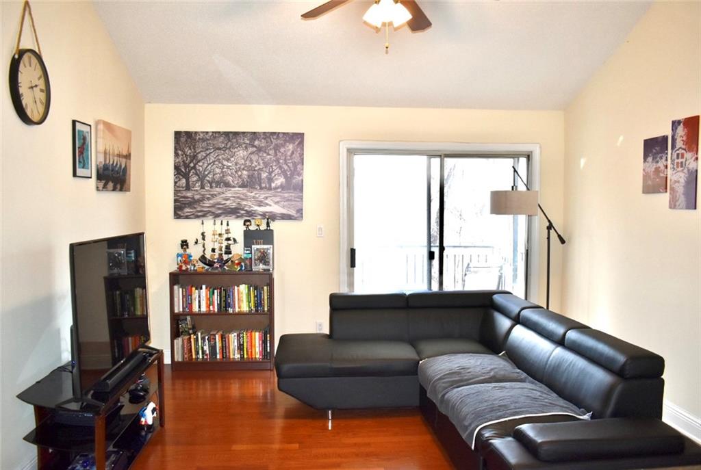 Living room featuring dark hardwood / wood-style flooring and ceiling fan