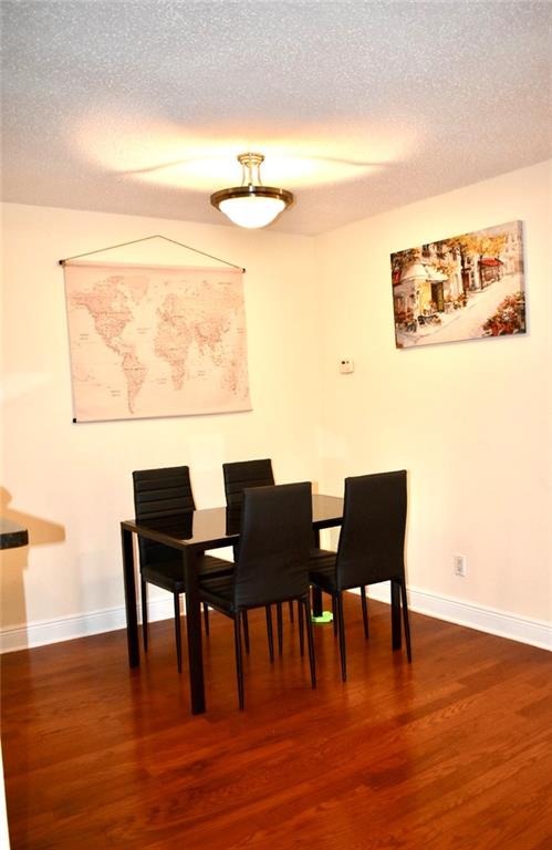 Dining space featuring dark wood-type flooring and a textured ceiling