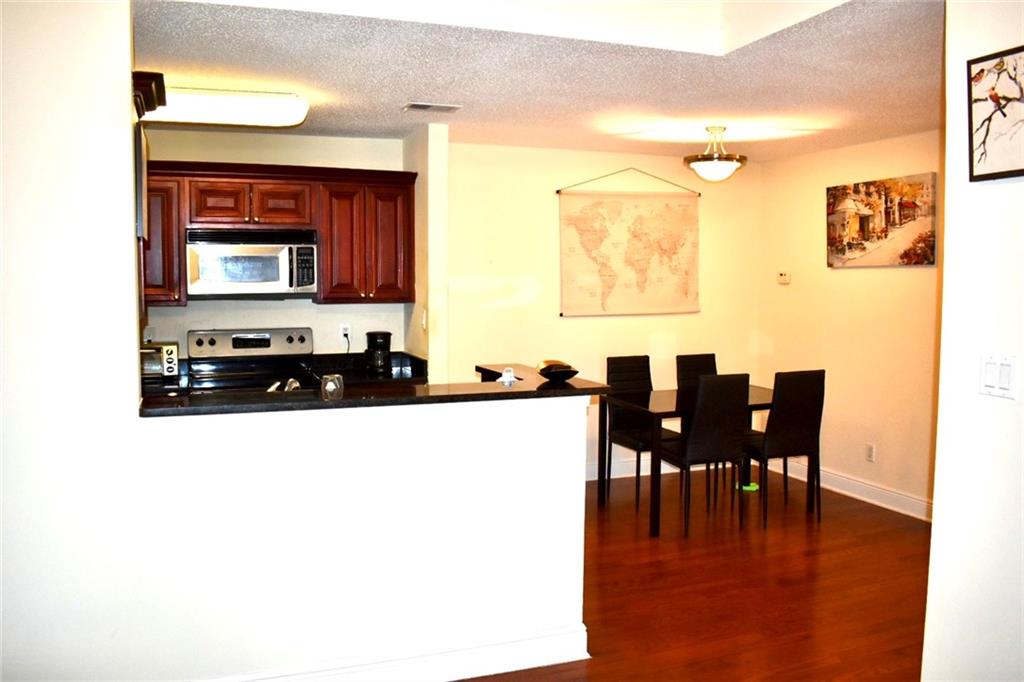 Kitchen featuring a textured ceiling, appliances with stainless steel finishes, and kitchen peninsula