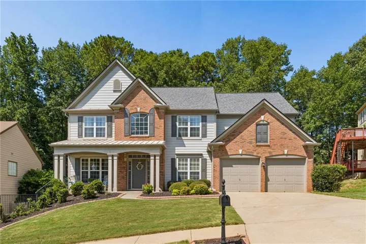 Brick and siding exterior with a covered porch featuring columns