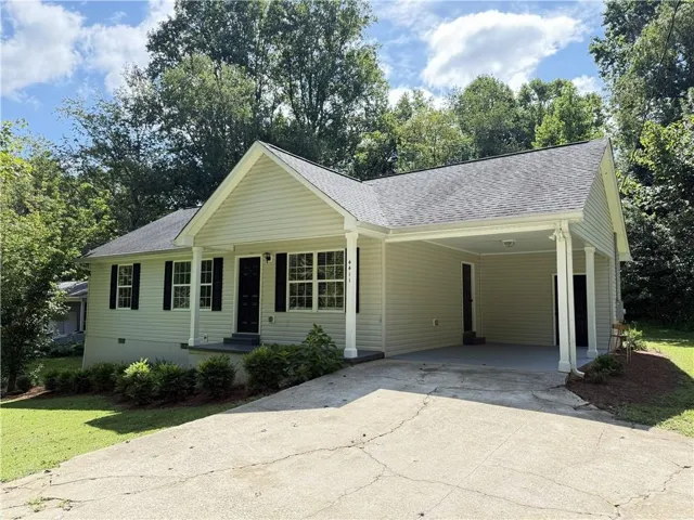 Siding exterior with a covered carport and a concrete driveway