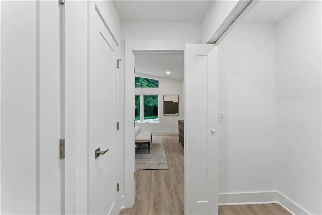 Hall with light wood-type flooring and recessed lighting