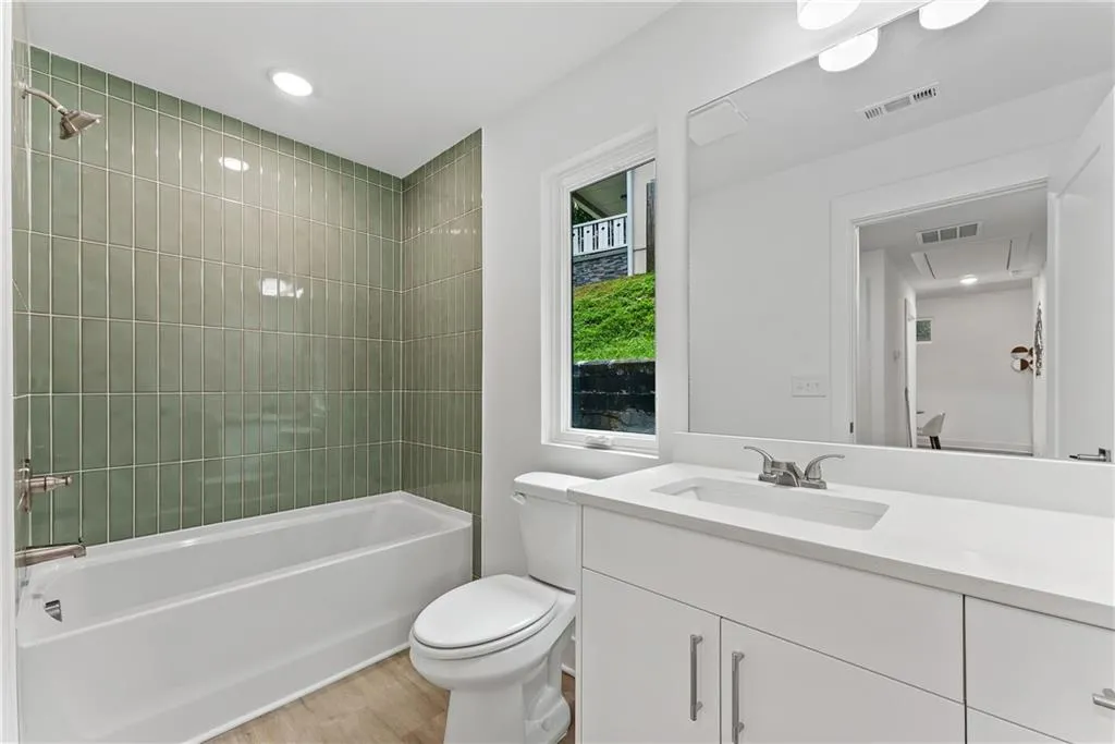 Full bath featuring vanity, wood finished floors, shower / bathtub combination, and recessed lighting