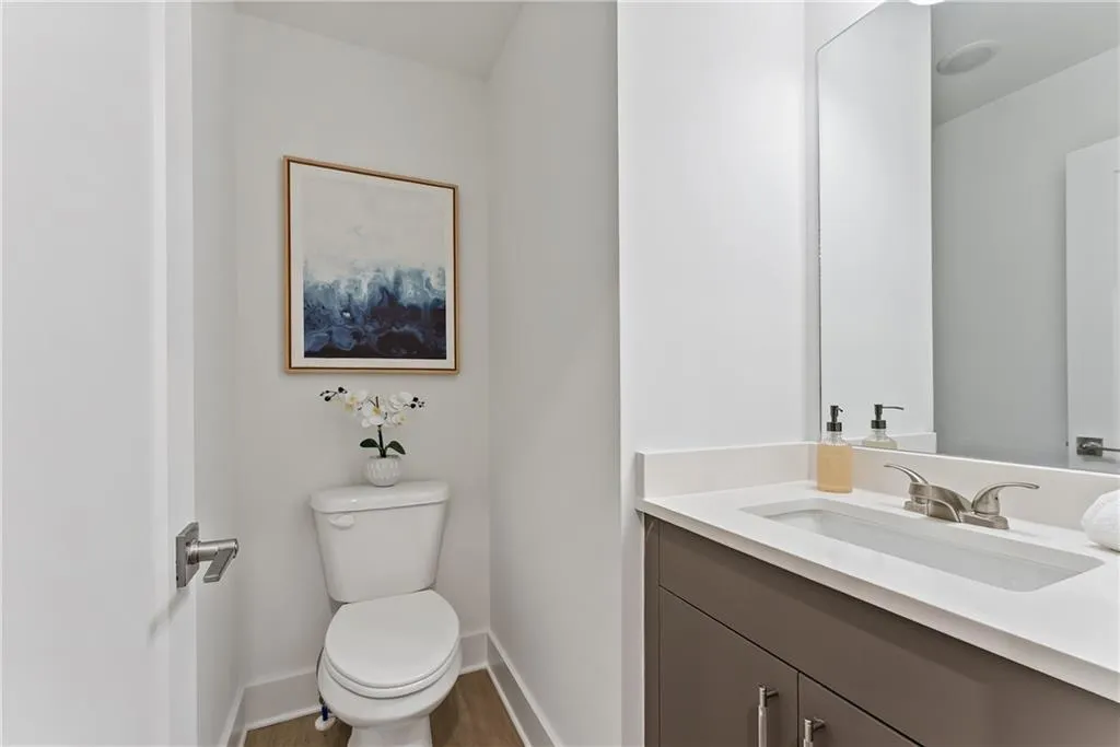 Half bathroom with vanity and wood finished floors